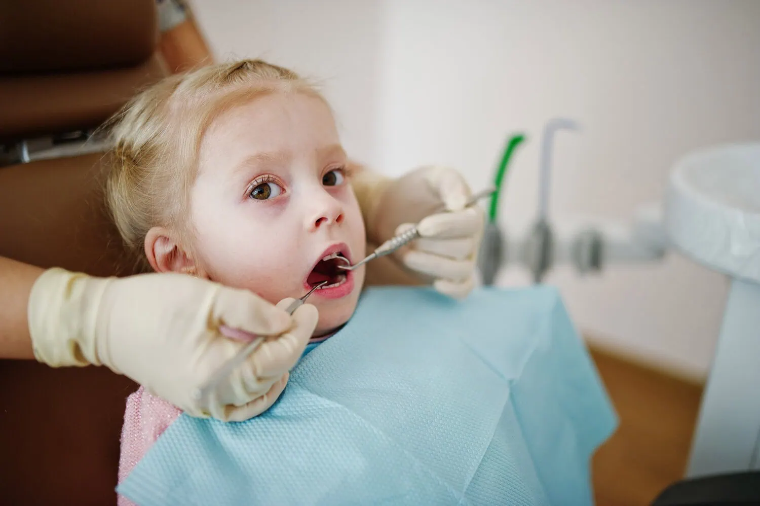 A dental professional examines a child’s teeth.