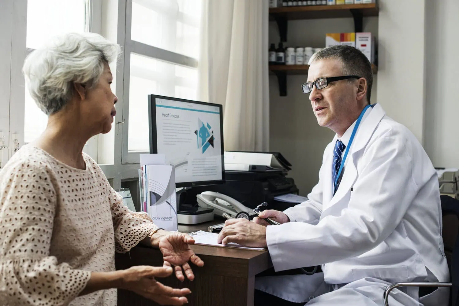 A doctor meets with a patient in an office.