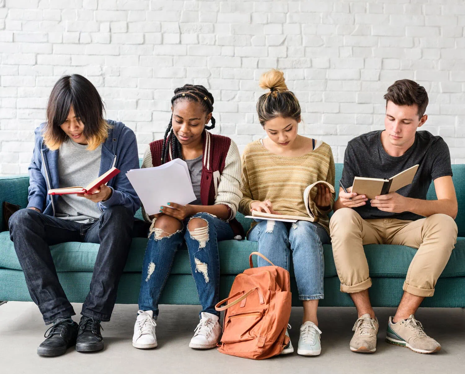 Four students read and study together.